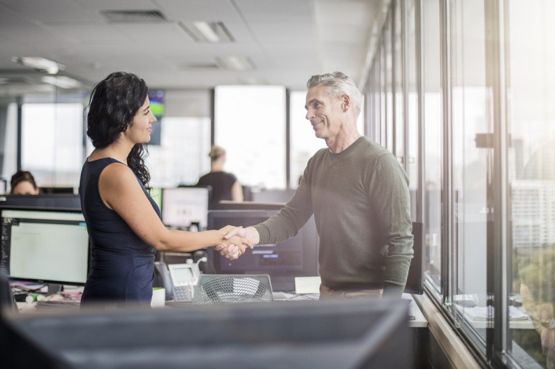 A new employee and their manager shaking hands