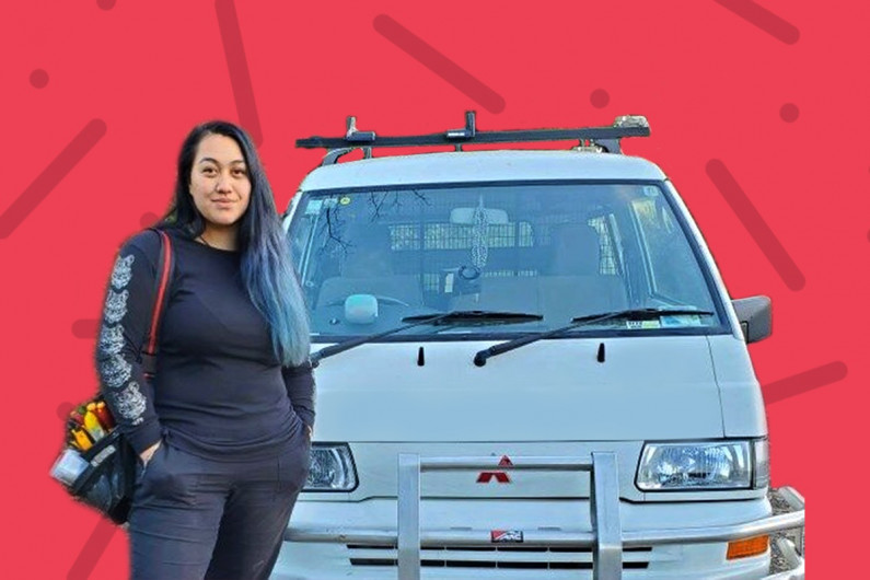 Cori Potaka, electrical engineering technician stands in front of her work van