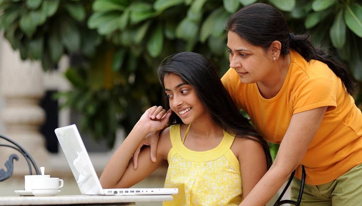 Mother with daughter looking at laptop