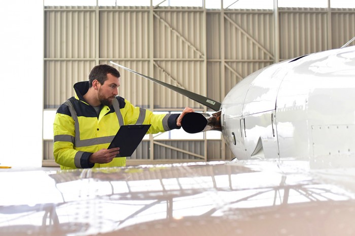 Aeronautical engineer inspects an aeroplane in an airport hangar