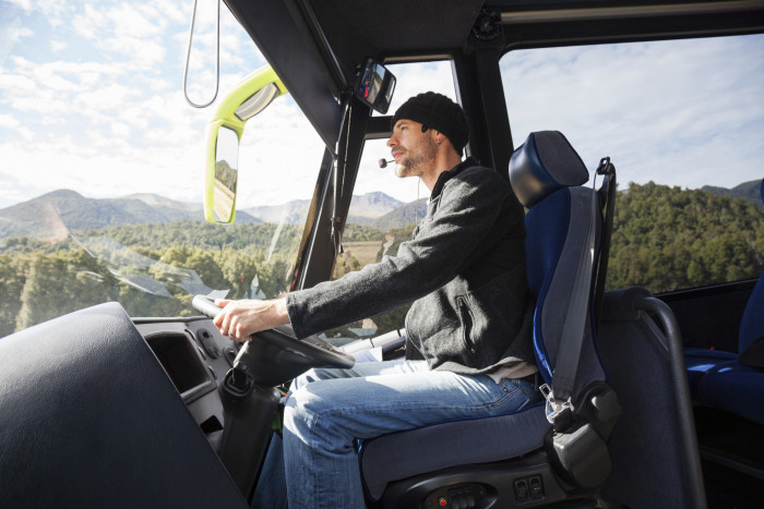 A tour coach driver drives a bus In Fiordland