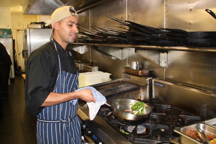 Kuman Ghosh sautes vegetables in a restaurant kitchen