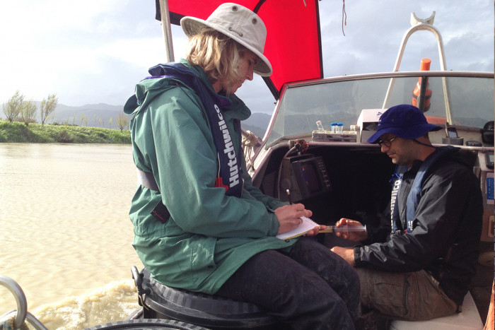 Professors Karin Bryan and Isaac Santos on a boat monitoring water quality in the Waihou River near Thames