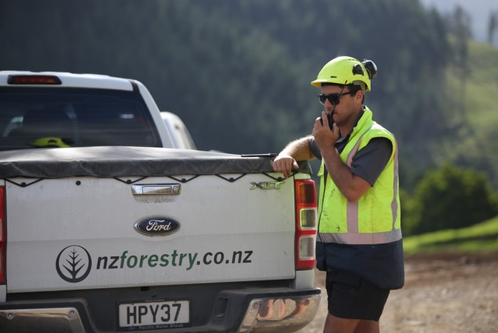 Forest manager standing by a vehicle and talking on his cellphone