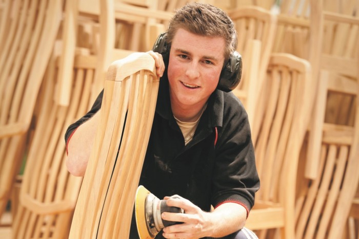 Furniture finisher sanding a chair