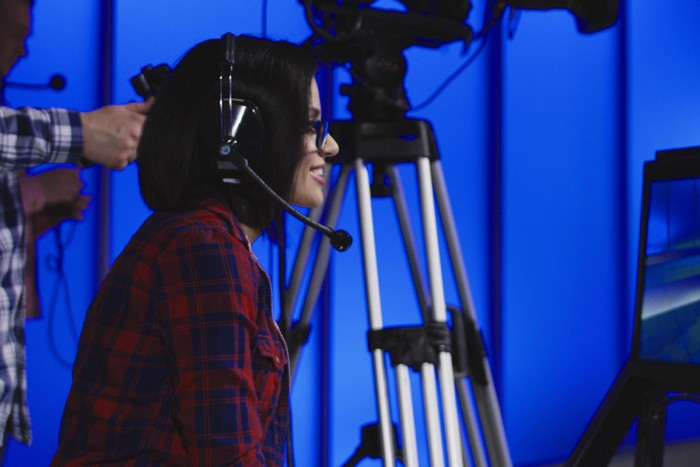 A media producer oversees taping of a news programme