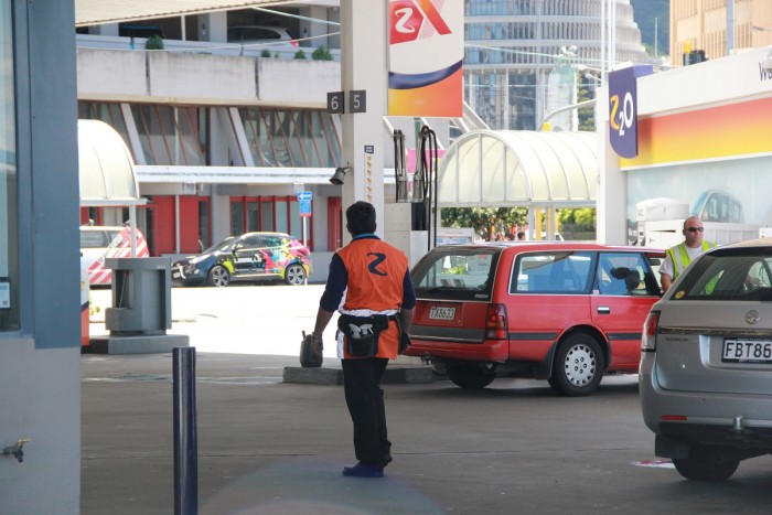 A service station attendant in the forecourt of a service station