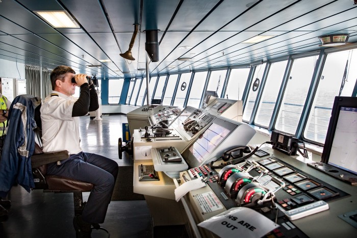 Ship's officer looks through binoculars out to sea