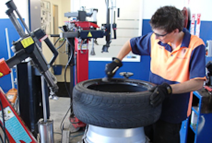 Sam Ruddles working on a tyre in a workshop