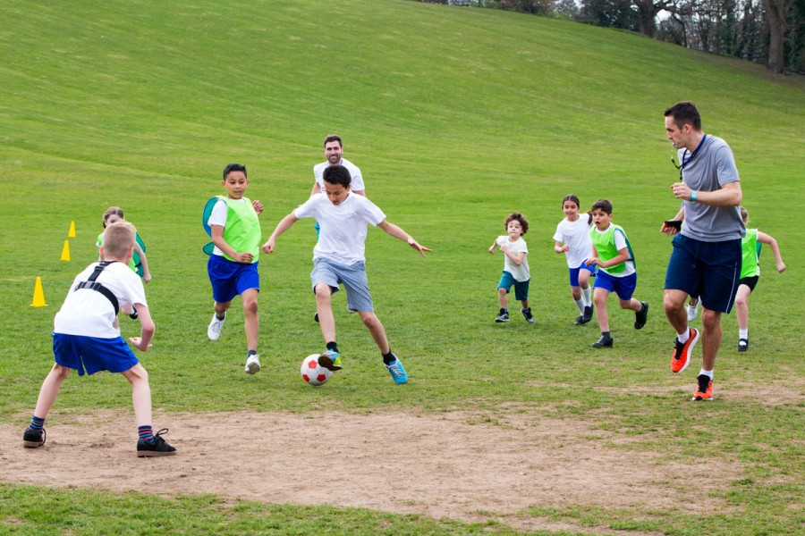 A group of primary school students play football