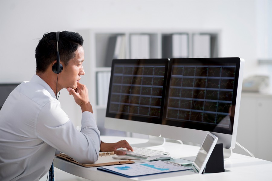 A worker looks at financial data on screen